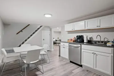 a kitchen with white cabinets and a table and chairs at Fishing & Skate Park, 10 mins to Ark, Sleeps 14 in Dry Ridge