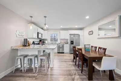 a kitchen with a table and some chairs and a counter at Fishing & Skate Park, 10 mins to Ark, Sleeps 14 in Dry Ridge