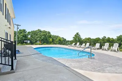 a swimming pool with lounge chairs and a pool at Country Lodge for 18, With Pool and Pond, Near Ark in Williamstown