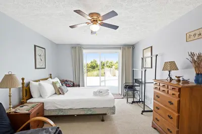 a bedroom with a bed and a ceiling fan at Country Lodge for 18, With Pool and Pond, Near Ark in Williamstown