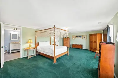 a bedroom with a canopy bed and a green carpet at Country Lodge for 18, With Pool and Pond, Near Ark in Williamstown