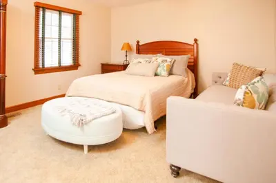 a bedroom with a bed and a ottoman at Millsite Lodge in Sandusky