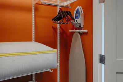 a room with a bunk bed with an orange wall at TownePlace Suites Columbus Hilliard in Hilliard