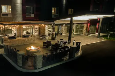 an outdoor patio with a fire pit at night at TownePlace Suites Columbus Hilliard in Hilliard