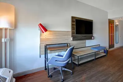 a room with a desk and a chair and a television at Tru By Hilton Monroe, Oh in Monroe