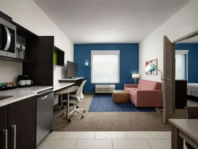 a living room with a couch and a desk at Home2 Suites Troy, OH in Troy