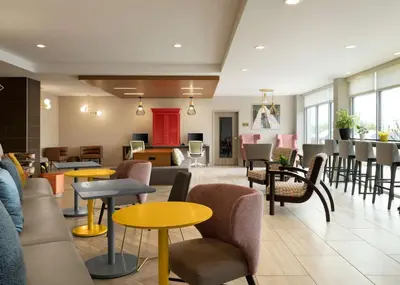 a lobby with tables and chairs and a waiting room at Home2 Suites Troy, OH in Troy