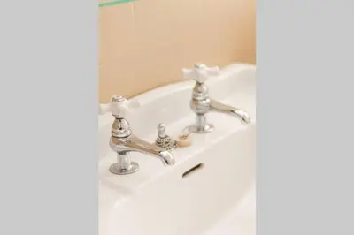 a white bathroom sink with two faucets on it at Homestead at Millsite Lodge in Sandusky