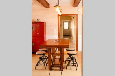 a dining room with a wooden table and stools at Homestead at Millsite Lodge in Sandusky
