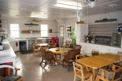a dining room with tables and chairs and a kitchen at Homestead at Millsite Lodge in Sandusky