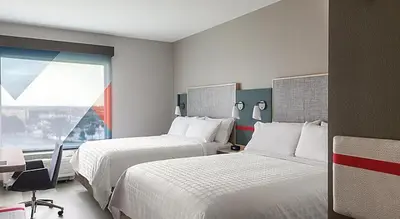 a hotel room with two beds and a window at avid hotels - Columbus Northwest - Hilliard by IHG in Hilliard