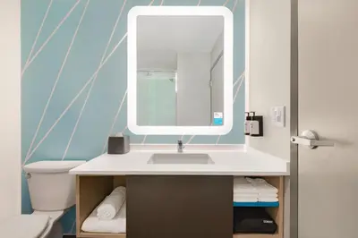 a bathroom with a sink and a mirror at avid hotels - Columbus Northwest - Hilliard by IHG in Hilliard