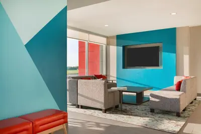a living room with a couch and a tv at avid hotels - Columbus Northwest - Hilliard by IHG in Hilliard