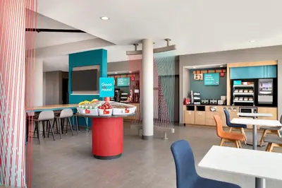 a restaurant with tables and chairs and a counter at avid hotels - Columbus Northwest - Hilliard by IHG in Hilliard