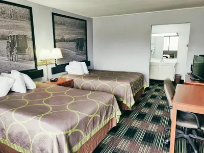 a hotel room with two beds and a desk at Sprucewood Inn in Elyria