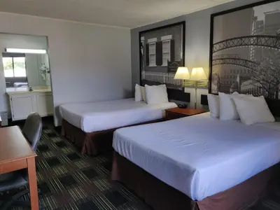 a hotel room with two beds and a desk at Sprucewood Inn in Elyria