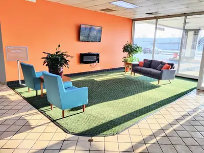 a lobby with chairs and a couch and a tv at Sprucewood Inn in Elyria