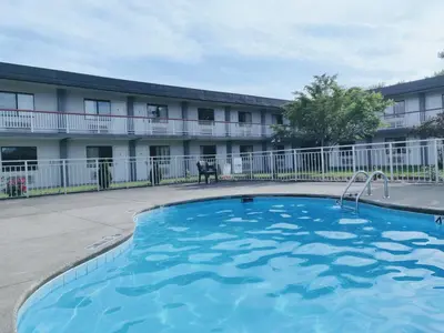 a large swimming pool in front of a building at Sprucewood Inn in Elyria