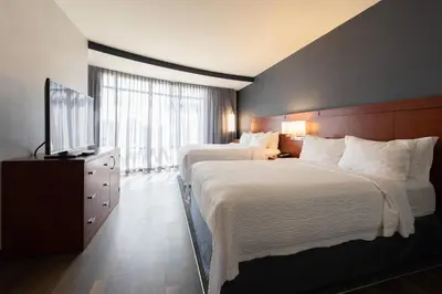 a hotel room with two beds and a television at Courtyard by Marriott Cincinnati Midtown/Rookwood in Cincinnati