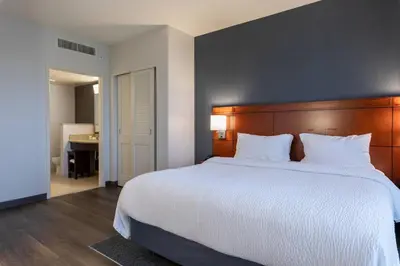a bedroom with a large bed and a bathroom at Courtyard by Marriott Cincinnati Midtown/Rookwood in Cincinnati