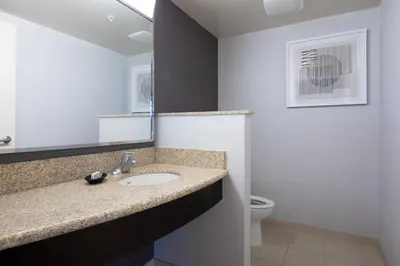 a bathroom with a sink and a mirror and a toilet at Courtyard by Marriott Cincinnati Midtown/Rookwood in Cincinnati