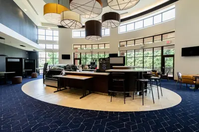an office lobby with tables and chairs and windows at Courtyard by Marriott Cincinnati Midtown/Rookwood in Cincinnati