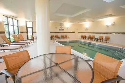a pool with a table and chairs around it at Courtyard by Marriott Cincinnati Midtown/Rookwood in Cincinnati