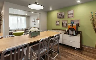 a dining room with a large wooden table and chairs at WoodSpring Suites Columbus Urbancrest in Grove City