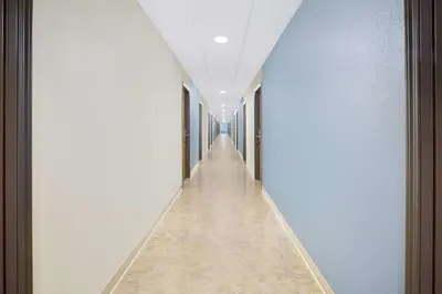 a long corridor with blue walls and a long hallway at WoodSpring Suites Columbus Urbancrest in Grove City
