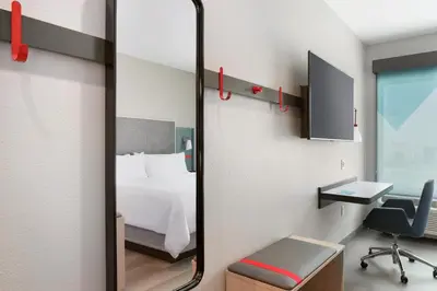 a mirror in a room with a bed and a desk at Avid Hotels - Cincinnati N - West Chester by IHG in West Chester