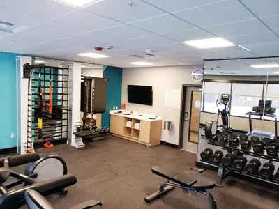 a gym with cardio equipment and a television in a room at Avid Hotels - Cincinnati N - West Chester by IHG in West Chester