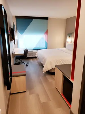 a hotel room with two beds and a desk at Avid Hotels - Cincinnati N - West Chester by IHG in West Chester