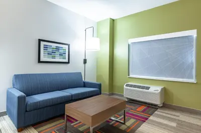 a living room with a blue couch and a tv at Holiday Inn Express & Suites - Moundsville by IHG in Moundsville