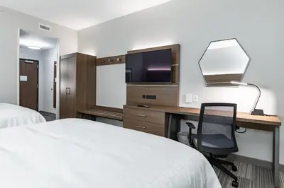 a hotel room with a desk with a tv and a chair at Holiday Inn Express & Suites - Moundsville by IHG in Moundsville