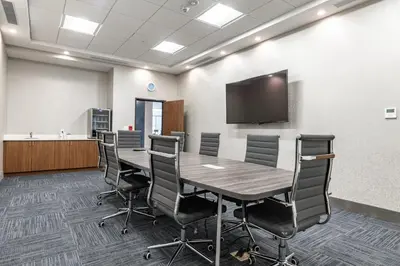 a conference room with a table and chairs and a flat screen tv at Holiday Inn Express & Suites - Moundsville by IHG in Moundsville