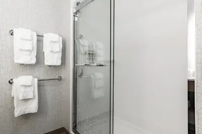 a bathroom with a shower with white towels at Holiday Inn Express & Suites - Moundsville by IHG in Moundsville
