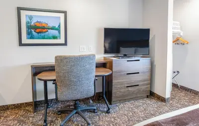 a room with a desk and a tv and a table and chairs at My Place Hotel-Marion, OH in Marion