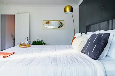 a white bedroom with a large white bed with pillows at Jungle House Luxury Homes - Columbus Downtown Short North - Steps to Convention Center & Nationwide Arena - Sleeps up to 11 - Free Parking - Over 5,800 Five Stars in Columbus
