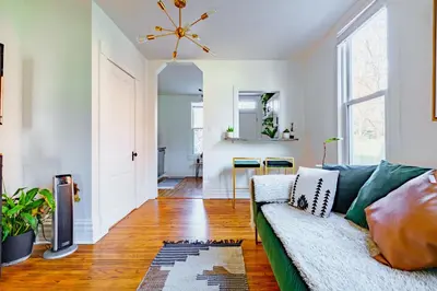 a living room with a green couch and a dining room at Jungle House Luxury Homes - Columbus Downtown Short North - Steps to Convention Center & Nationwide Arena - Sleeps up to 11 - Free Parking - Over 5,800 Five Stars in Columbus