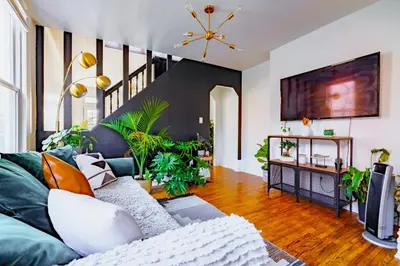 a living room with a couch and some plants at Jungle House Luxury Homes - Columbus Downtown Short North - Steps to Convention Center & Nationwide Arena - Sleeps up to 11 - Free Parking - Over 5,800 Five Stars in Columbus