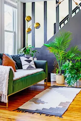 a living room with a green couch and plants at Jungle House Luxury Homes - Columbus Downtown Short North - Steps to Convention Center & Nationwide Arena - Sleeps up to 11 - Free Parking - Over 5,800 Five Stars in Columbus