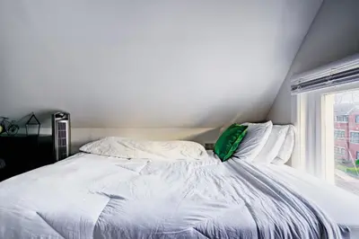 a white bed in a room with a window at Jungle House Luxury Homes - Columbus Downtown Short North - Steps to Convention Center & Nationwide Arena - Sleeps up to 11 - Free Parking - Over 5,800 Five Stars in Columbus