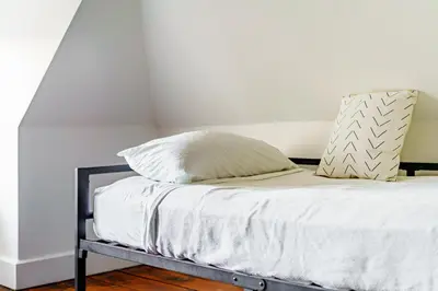 a bed with white sheets and pillows on it at Jungle House Luxury Homes - Columbus Downtown Short North - Steps to Convention Center & Nationwide Arena - Sleeps up to 11 - Free Parking - Over 5,800 Five Stars in Columbus