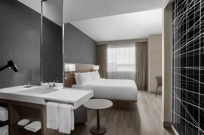 a hotel room with a bed and a sink at AC Hotel by Marriott Pittsburgh Southpointe in Canonsburg