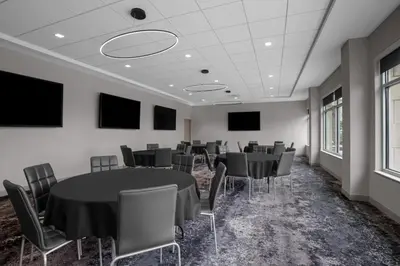 a conference room with tables and chairs and televisions at AC Hotel by Marriott Pittsburgh Southpointe in Canonsburg