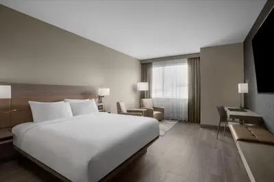 a bedroom with a large white bed and a desk at AC Hotel by Marriott Pittsburgh Southpointe in Canonsburg