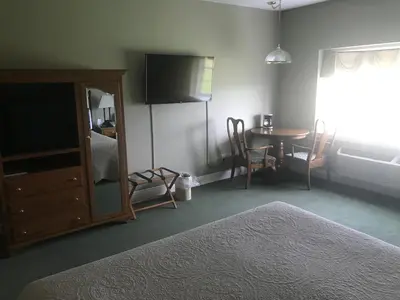 a bedroom with a bed and a table and a television at Inn at Amish Door in Wilmot