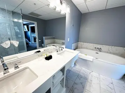 a bathroom with a tub and a sink and a bath tub at Inn at Amish Door in Wilmot
