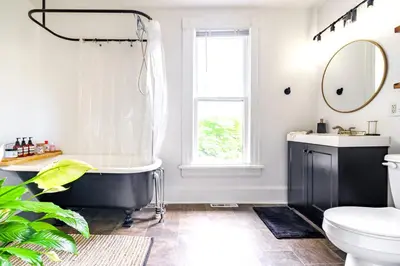 a bathroom with a black and white tub and a window at Jungle House Luxury Stays - Columbus Downtown Short North in Columbus
