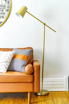a lamp sitting next to a couch with a pillow at Jungle House Luxury Stays - Columbus Downtown Short North in Columbus